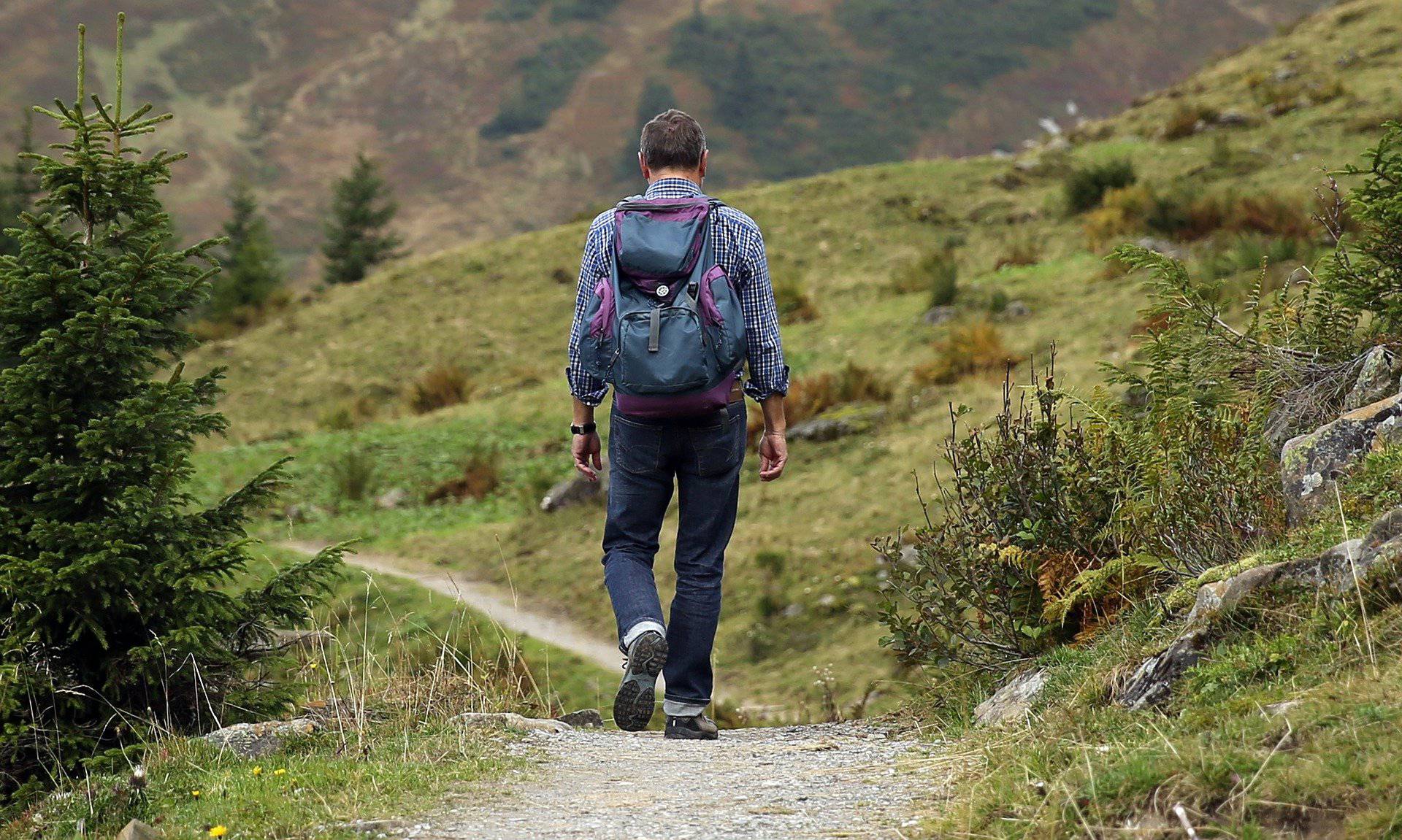 Man Hiking Down Trail with Backpack